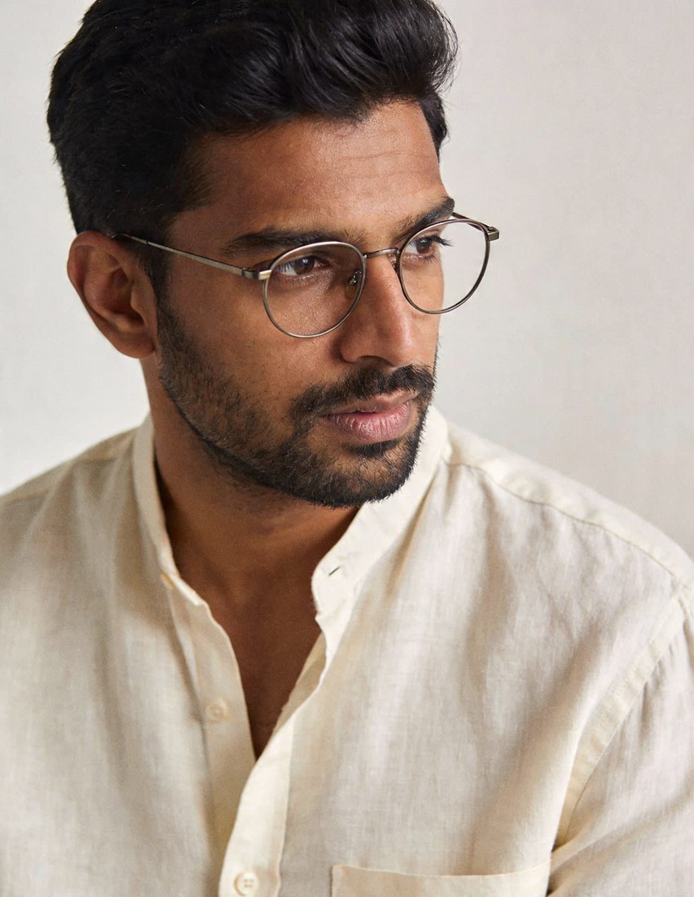 Man wearing round titanium eyeglasses — Eyesqure Optical